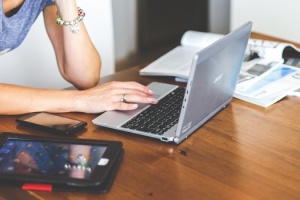 woman-hand-smartphone-laptop-medium
